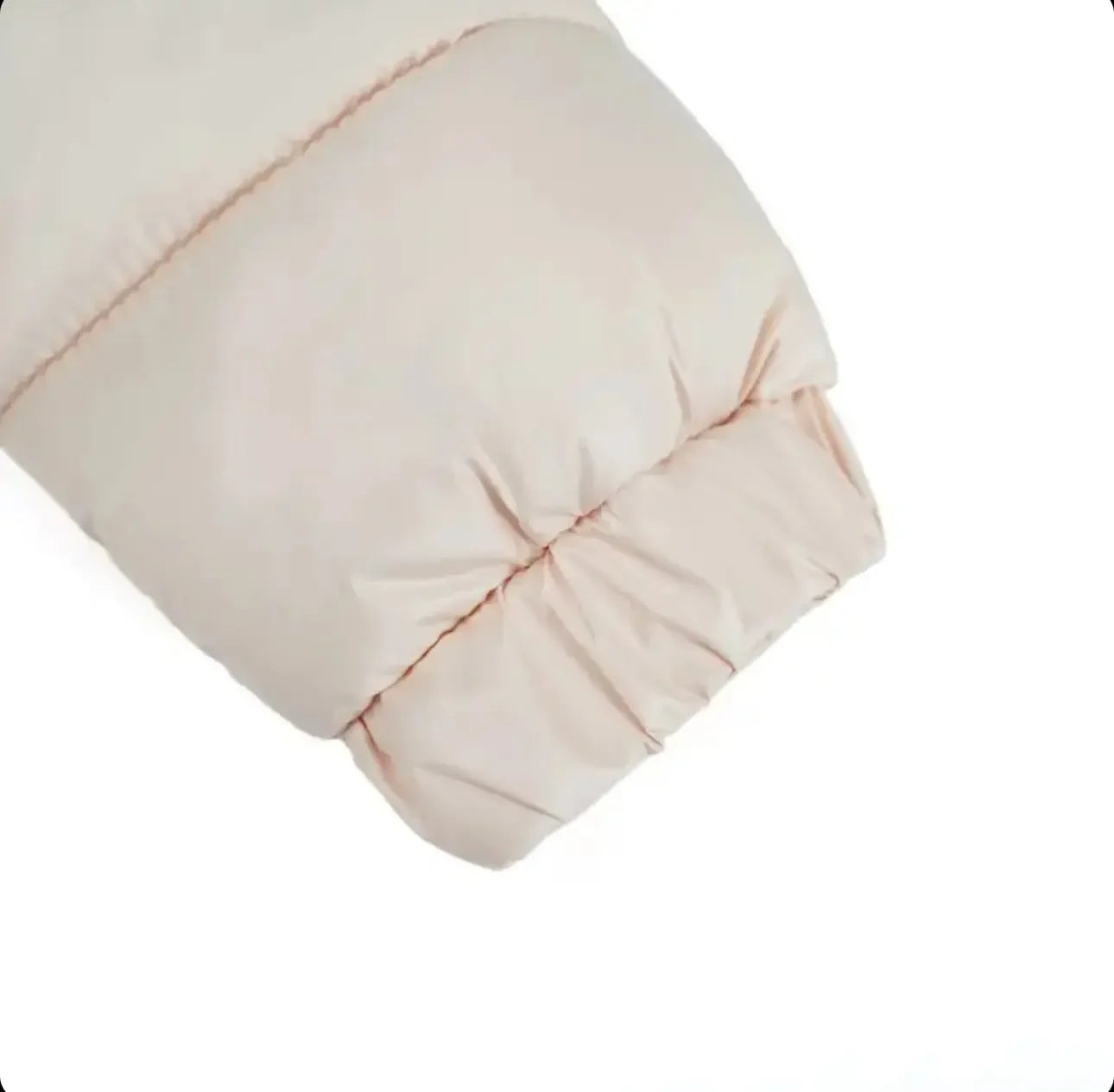 Beige puffer jacket sleeve with elastic cuff detail on white background