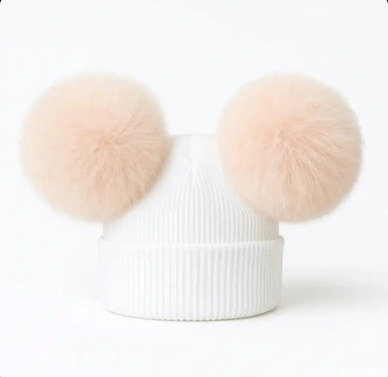 White ribbed knit beanie with two large beige faux fur pom-poms resembling ears