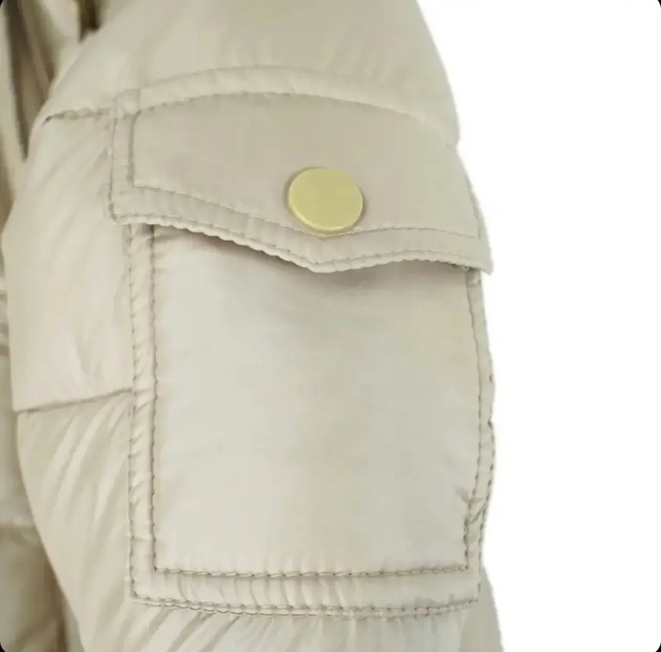 Close-up of beige padded jacket sleeve with a flap pocket secured by a round metallic snap button
