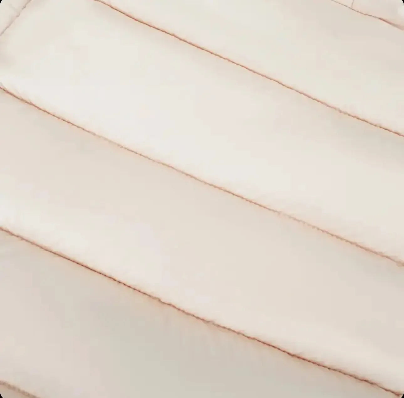 Close-up of beige quilted fabric with horizontal padded stitching