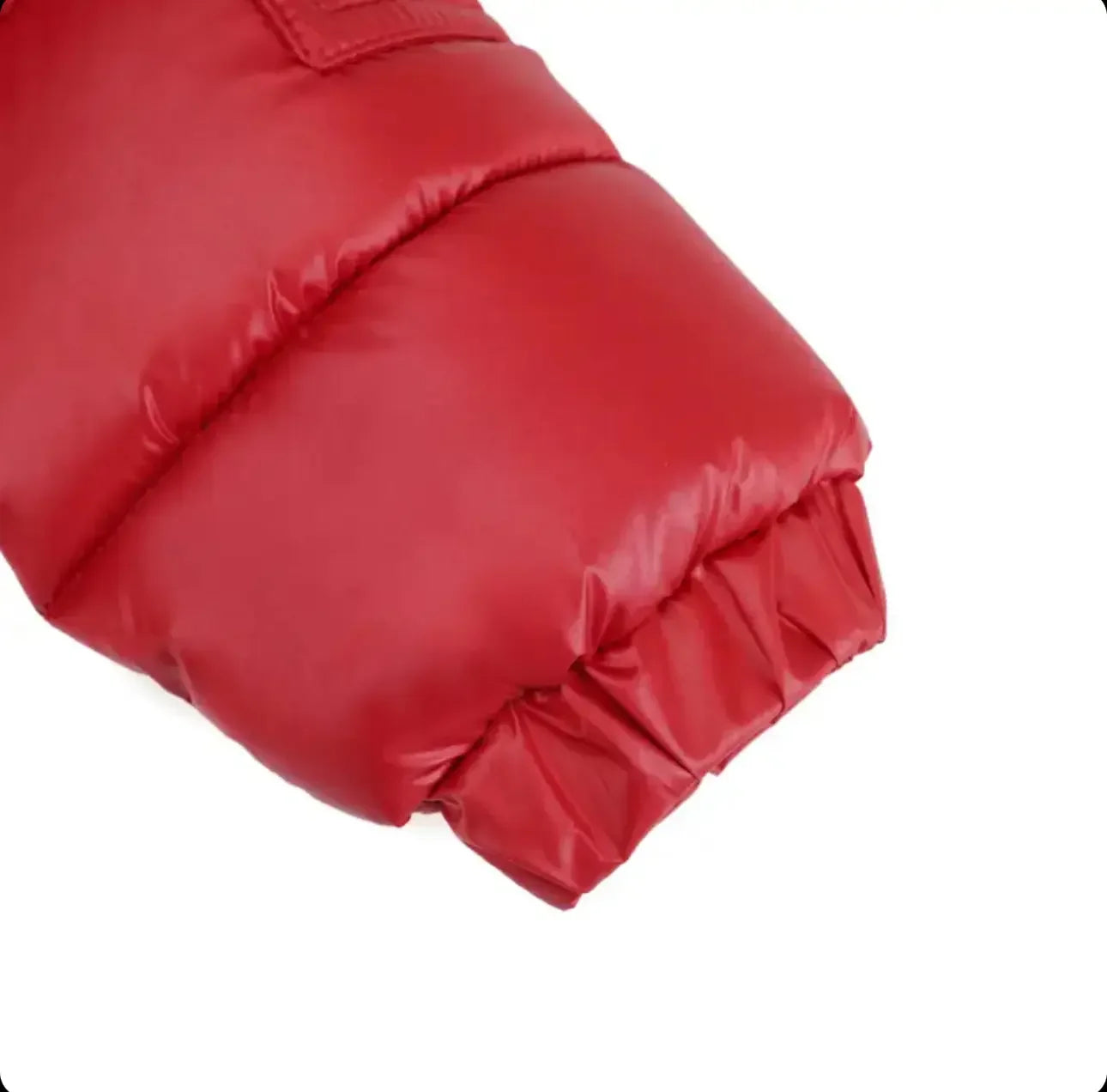 Close-up of red puffer jacket sleeve with elastic cuff on white background