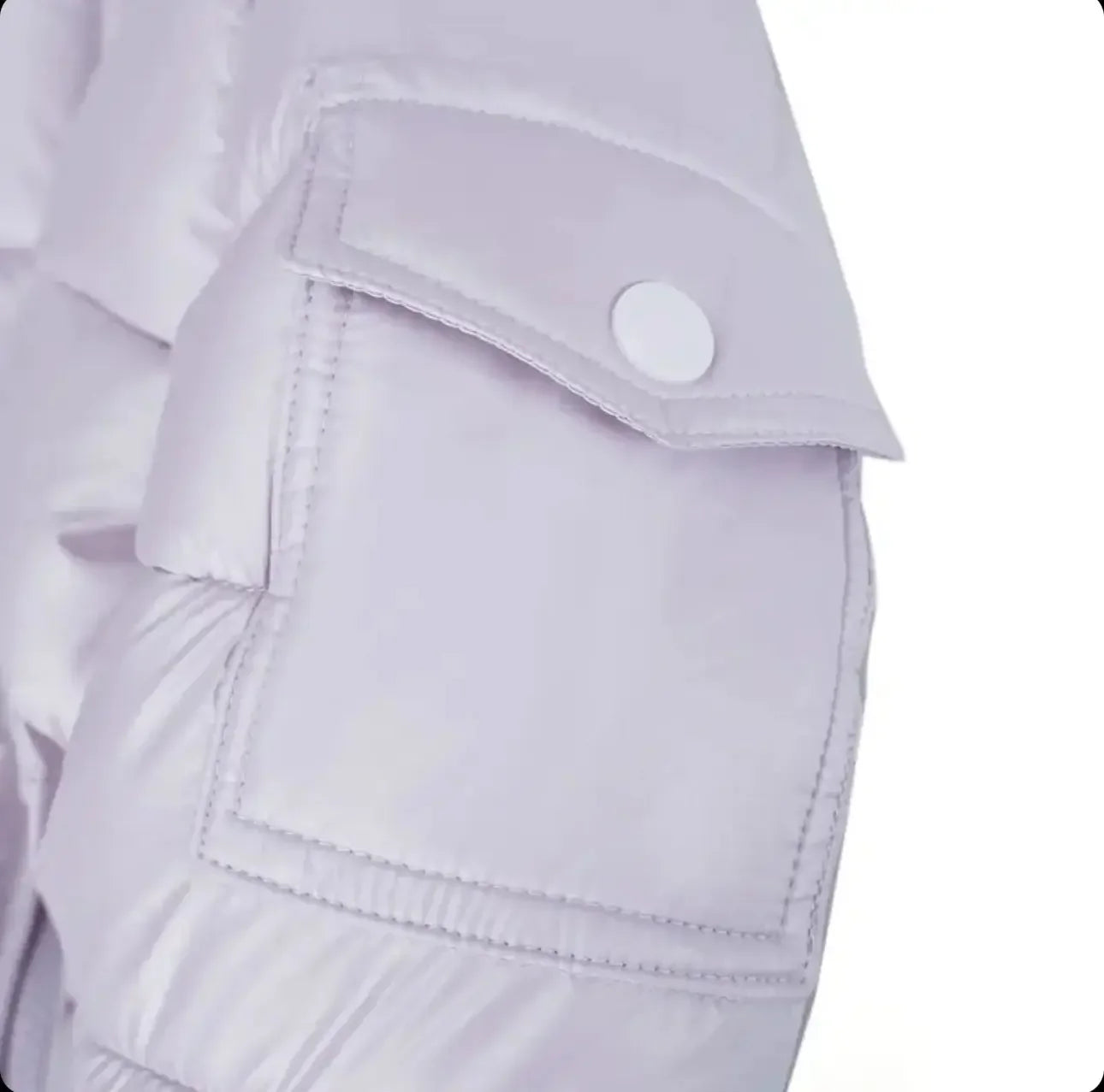 Close-up of a pale lavender puffer jacket sleeve with a stitched pocket and snap button