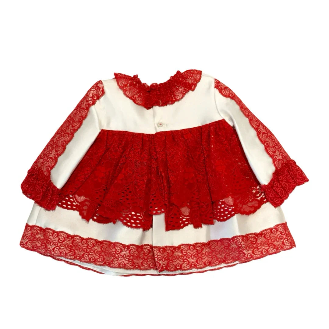 White baby dress with red lace overlay, ruffled collar, and long sleeves on white background
