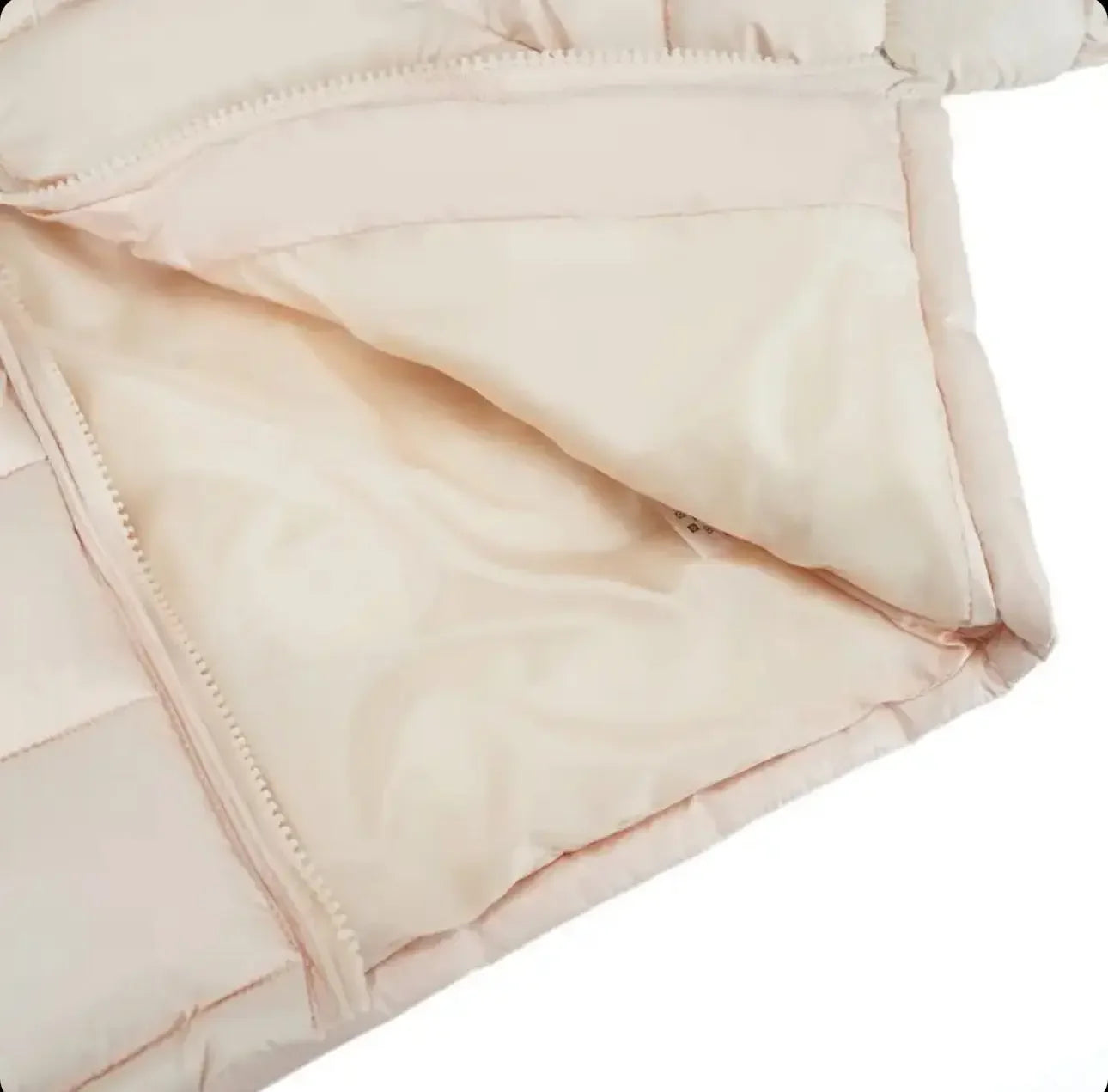 Close-up of beige puffer jacket interior and zipper detail on light background