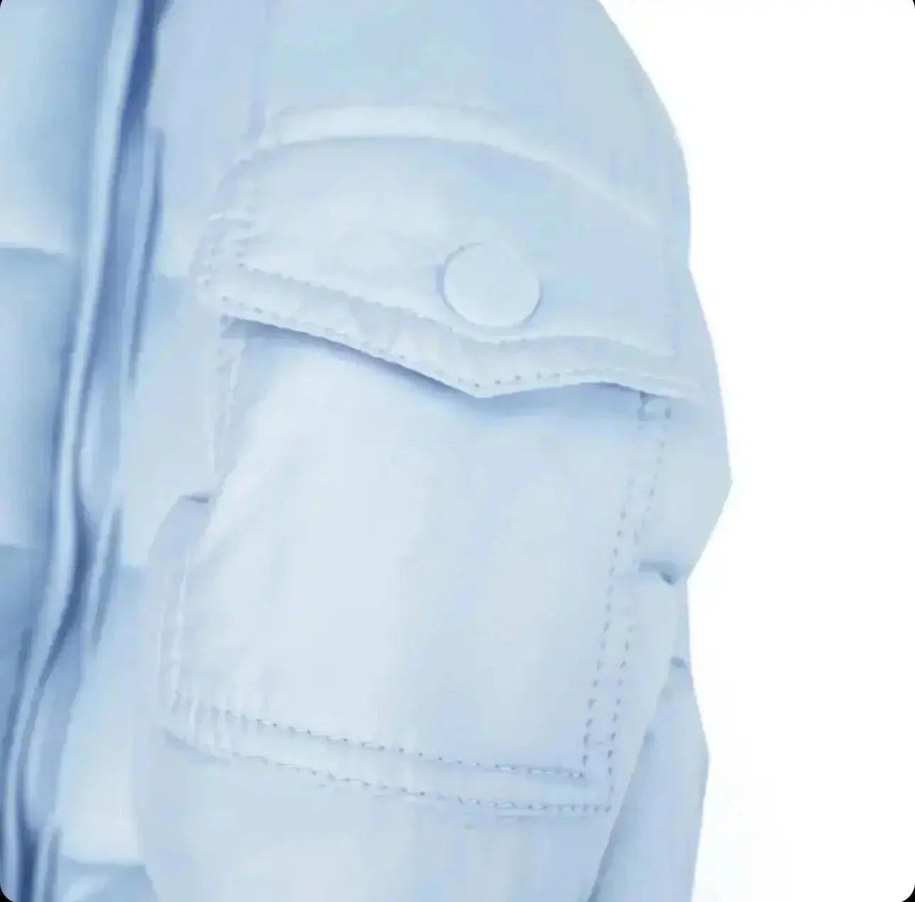 Close-up of light blue jacket sleeve with a flap pocket and snap button detail