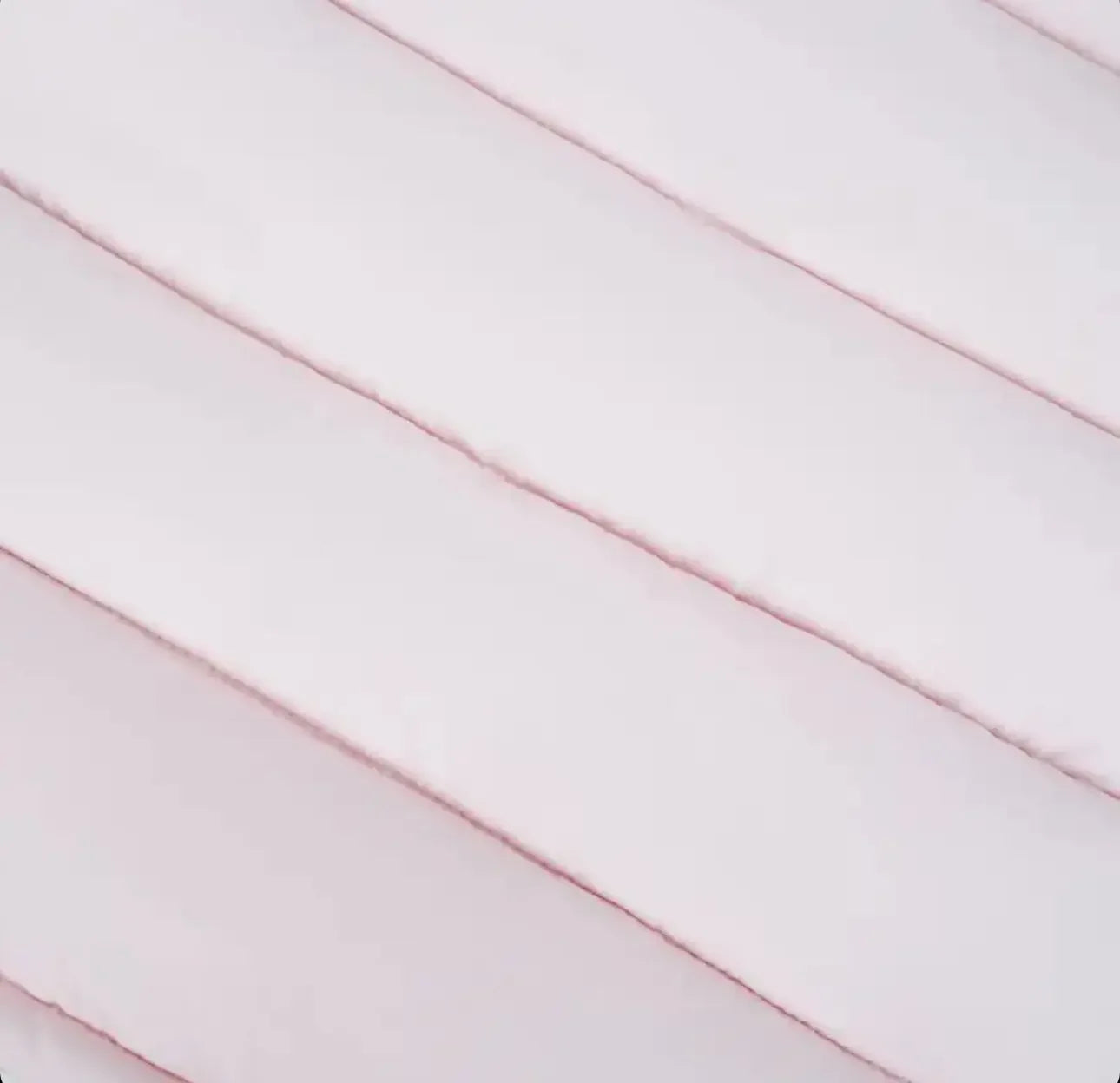 Close-up of soft, white, horizontally quilted fabric texture