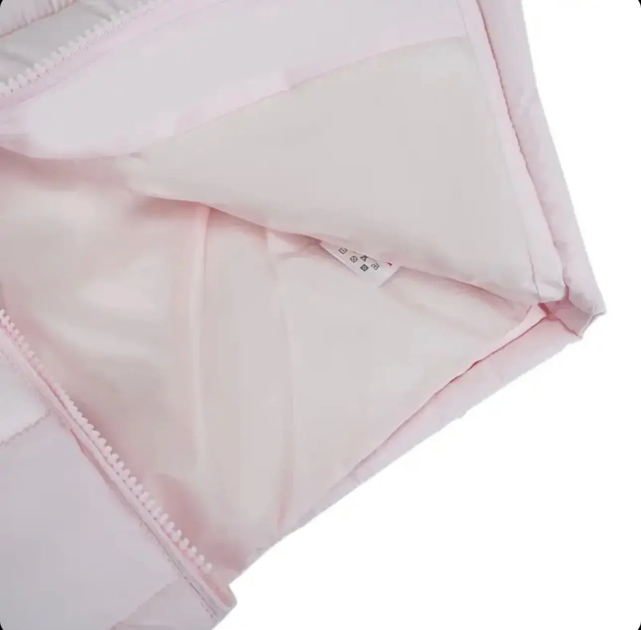 Close-up of light pink quilted jacket with zipper and fabric label inside