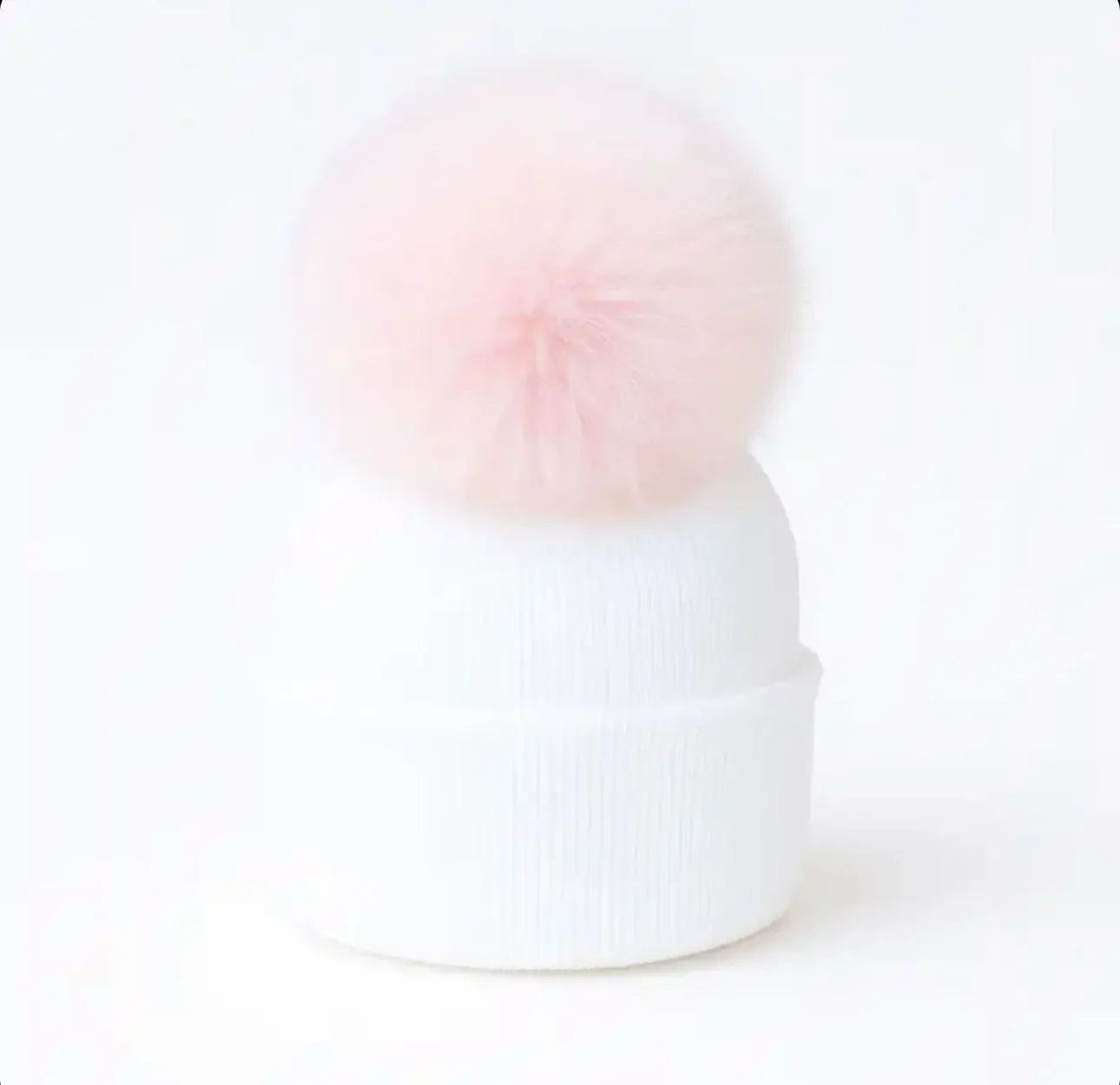 White knit beanie hat with a large fluffy pink pom pom on top