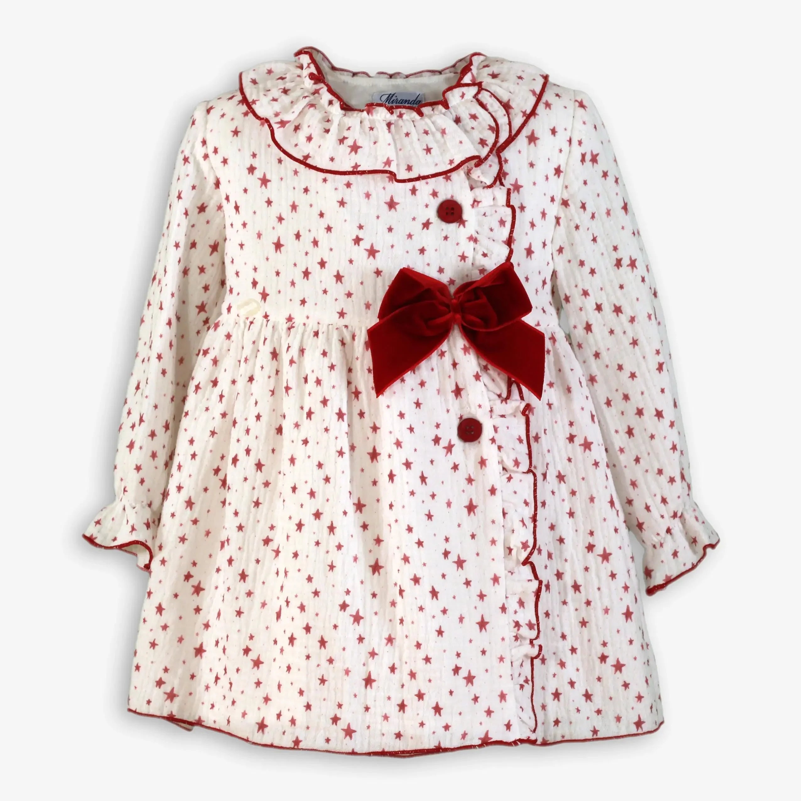 White baby dress with red star pattern, ruffled collar, red buttons, and large red velvet bow