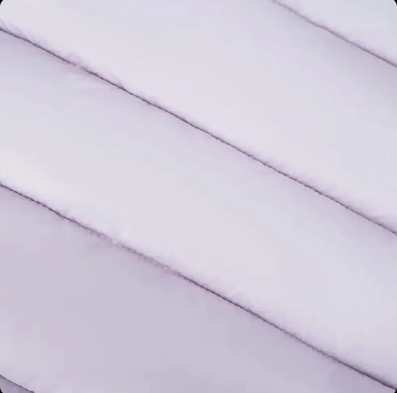 Close-up of textured, padded white fabric with horizontal stitched lines