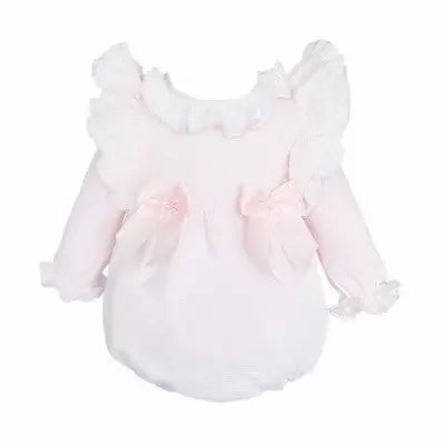 Soft pink baby romper with ruffled shoulders and floral bow accents on white background
