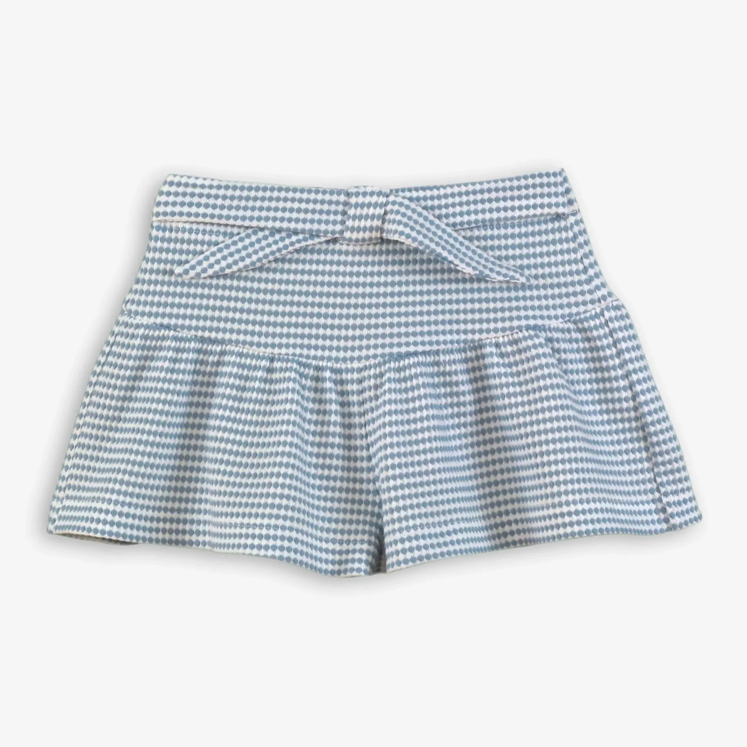 Blue and white polka dot toddler skirt with ruffled hem and bow belt on white background