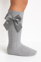 Gray cable knit knee-high sock with large satin bow detail on side
