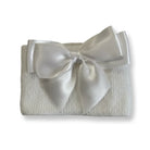 white knitted fabric folded with large satin white bow on top, minimalist gift wrap
