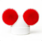 White ribbed knit beanie hat with two large bright red fluffy pom poms