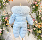 Light blue puffer toddler snowsuit with fluffy hood displayed on mannequin surrounded by colorful flowers
