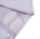 Close-up of light gray quilted fabric with zipper and visible care label