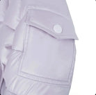 Close-up of a pale lavender puffer jacket sleeve with a stitched pocket and snap button