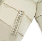Close-up of beige quilted jacket sleeve with zipper pocket detail