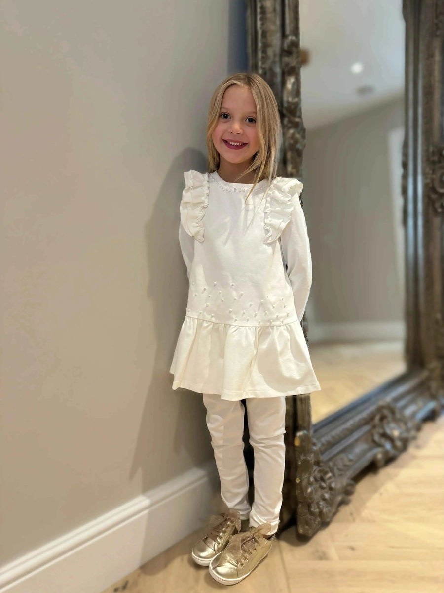 AW26 Bimbalo Girls Cream Pearl Legging Set, featuring a ruffled cream top and matching leggings. Available in sizes 18 Months to 8 Years.