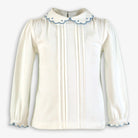 White long-sleeve girl's top with scalloped collar and blue trim, front pintuck details