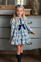 AW26 Rochy girls blue and ivory toile print dress with navy velvet bow, pearl details and tiered skirt, sizes 4 to 12 years