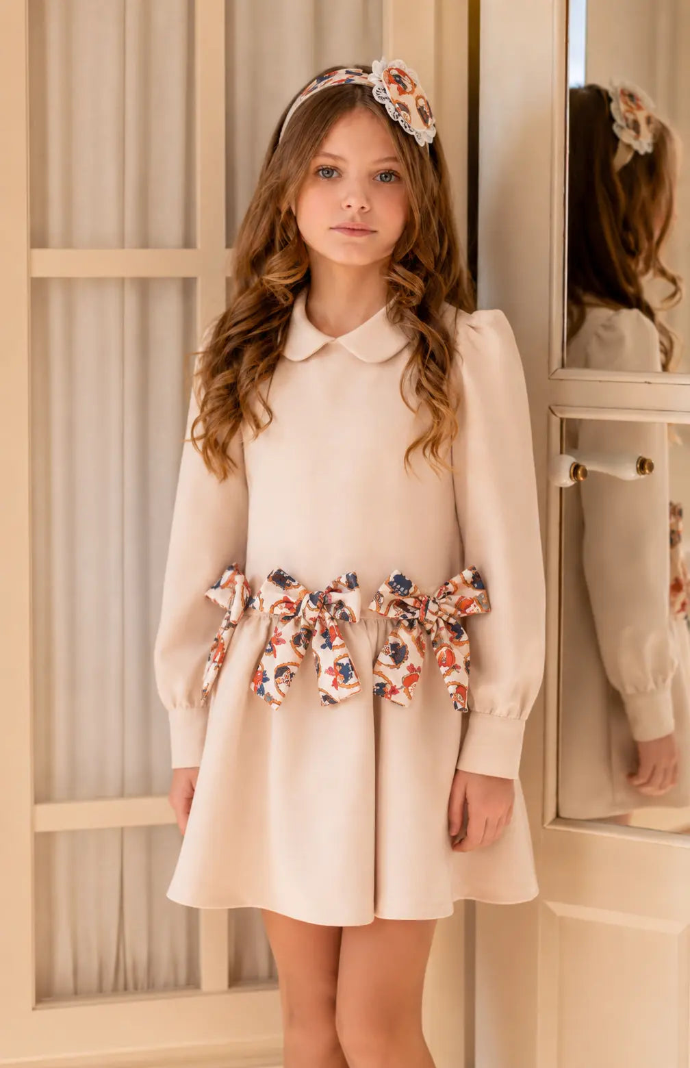 AW26 Rochy girls cream long sleeve dress with teddy bear print bows, ruffle waist detail and classic collar, sizes 2 to 8 years