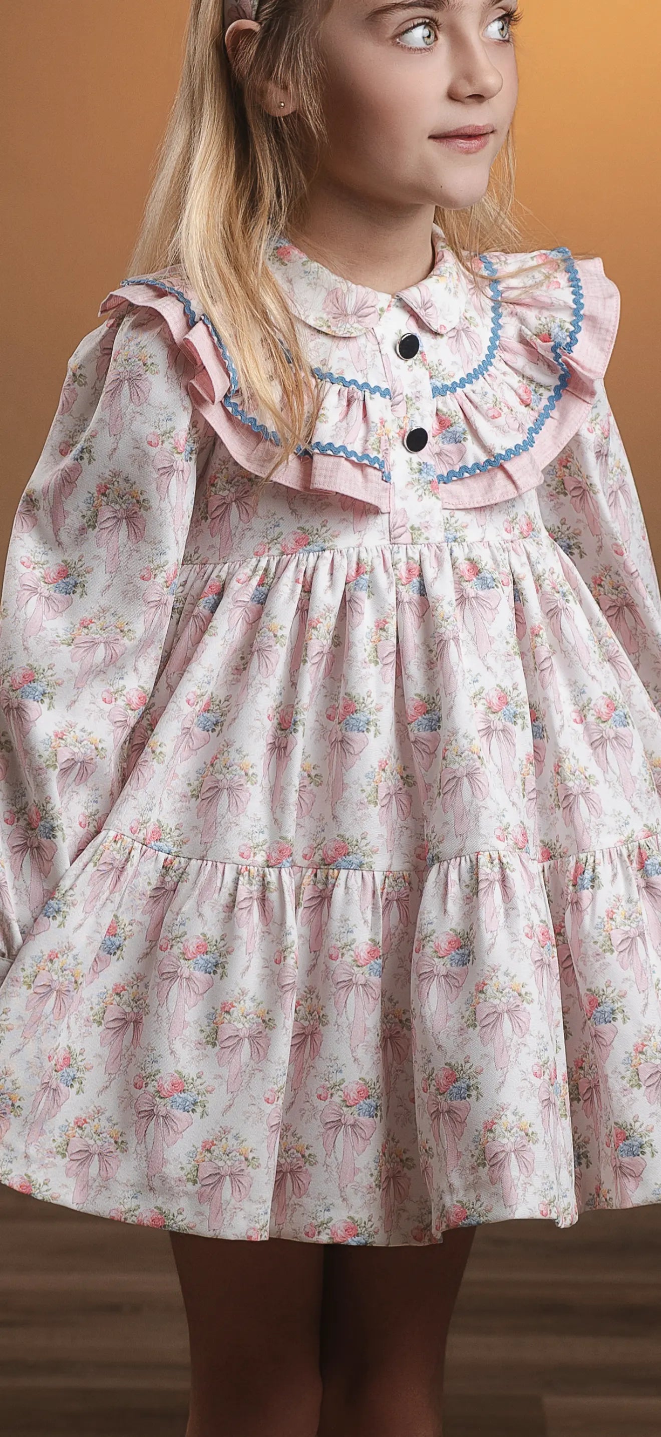 AW26 Rochy girls pink floral bow print dress with layered ruffle collar, blue trim and full tiered skirt, sizes 3 to 14 years
