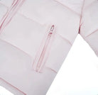Close-up of light pink padded jacket sleeve and zippered pocket with stitching details