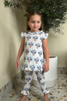 Young girl in blue hydrangea print soft touch loungewear set with ruffle details, indoor plant background