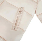 Close-up of a beige quilted puffer jacket with a zipper pocket on the sleeve