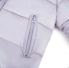 Close-up of light gray quilted jacket sleeve with silver zipper pocket detail