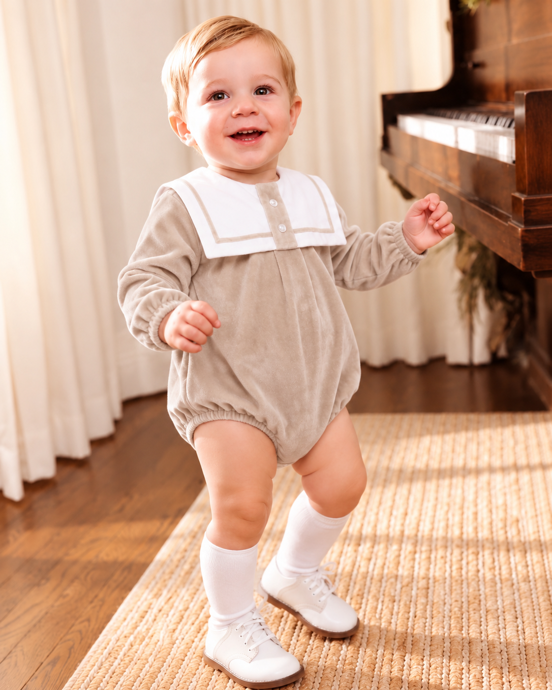Baby boy wearing a beige velour sailor collar romper with white knee-high socks and traditional baby shoes.