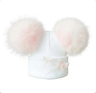 White baby knit hat with two large soft pink pom poms and delicate butterfly detail