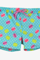 Blue swim shorts with white polka dots and colorful macaron print, pink drawstring at waist