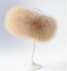 Light brown fluffy faux fur beret hat on white display stand