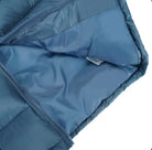 Close-up of light blue quilted jacket with open zipper showing smooth inner lining and fabric tag